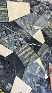 Custom Palladiana stone slab during fabrication at InStyle Stone workshop, featuring Verde Alpi marble, Nero Marquina marble, Tundra Grey marble, Four Seasons Quartz and Paglierino Travertine