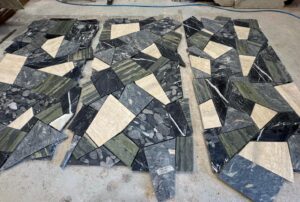 Hand-selected natural stone pieces arranged prior to fabrication of custom Palladiana stone slabs by InStyle Stone.